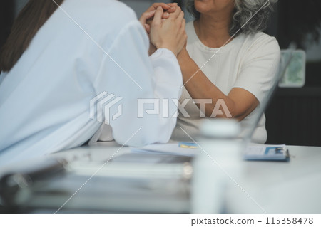 African female doctor hold hand of caucasian woman patient give comfort, express health care sympathy, medical help trust support encourage reassure infertile patient at medical visit, closeup view. African female doctor hold hand of caucasian woman patient give comfort, express health care sympathy, medical help trust support encourage reassure infertile patient at medical visit, closeup view. 115358478