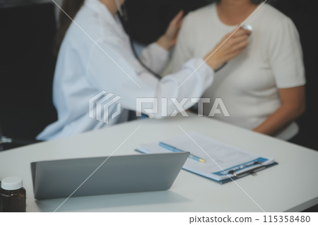 Doctor using sphygmomanometer with stethoscope checking blood pressure to a patient in the hospital. Doctor using sphygmomanometer with stethoscope checking blood pressure to a patient in the hospital. 115358480