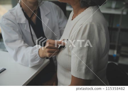 Doctor using sphygmomanometer with stethoscope checking blood pressure to a patient in the hospital. Doctor using sphygmomanometer with stethoscope checking blood pressure to a patient in the hospital. 115358482