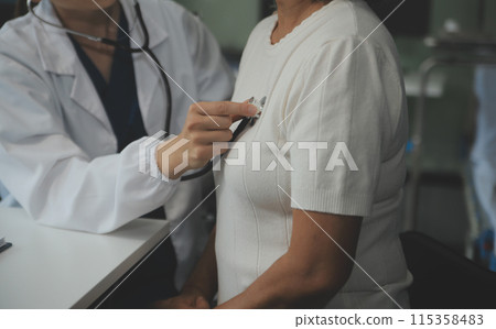 Doctor using sphygmomanometer with stethoscope checking blood pressure to a patient in the hospital. Doctor using sphygmomanometer with stethoscope checking blood pressure to a patient in the hospital. 115358483
