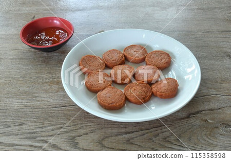 fried slice pork bologna sausage on plate dipping with ketchup and chili sauce fried slice pork bologna sausage on plate dipping with ketchup and chili sauce 115358598