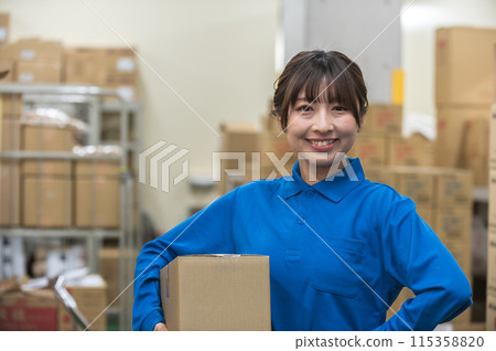 Young female worker holding cardboard boxes in warehouse 115358820