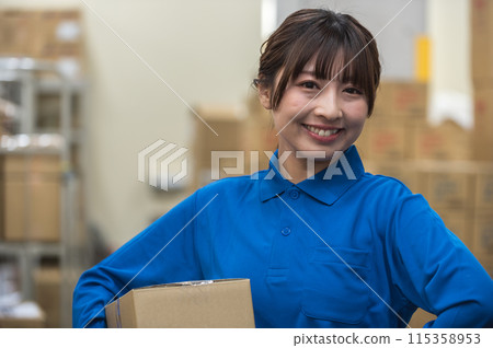 Young female worker holding cardboard boxes in warehouse Young female worker holding cardboard boxes in warehouse 115358953
