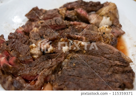Medium rare sliced sirloin meat on the white cutting board 115359371