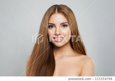 Lovely woman with long hair and fresh clean skin studio portrait on grey background.  115359799