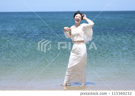A woman walking on a beautiful tropical beach 115360232