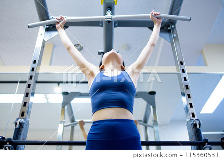Woman working out at the gym, lat pulldown, female muscle training, workout, front 115360531