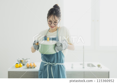 Young woman standing in the kitchen Young woman standing in the kitchen 115360952
