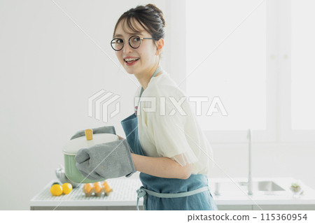 站在廚房裡的年輕女子 115360954