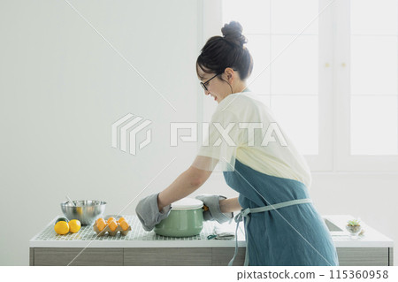 站在廚房裡的年輕女子 115360958