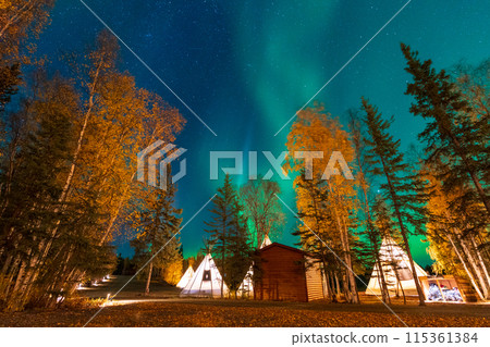 Amazing northern lights dancing over the light up Tipi or Tepees at Aurora Village in Yellowknife, Northwest Territories, Canada. 115361384