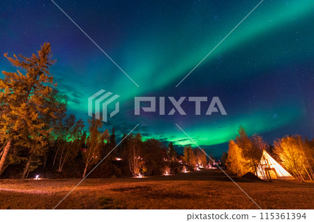 Amazing northern lights dancing over the light up Tipi or Tepees at Aurora Village in Yellowknife, Northwest Territories, Canada. Amazing northern lights dancing over the light up Tipi or Tepees at Aurora Village in Yellowknife, Northwest Territories, Canada. 115361394