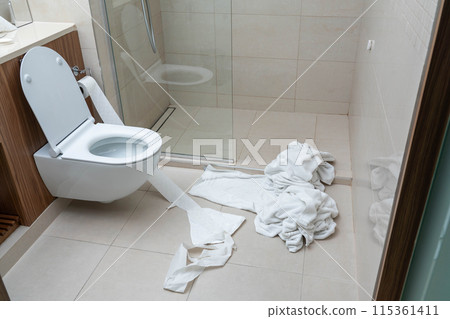 Dirty used towels on the floor in hotel bathroom. Concept of saving water, soap, energy as a green policy Dirty used towels on the floor in hotel bathroom. Concept of saving water, soap, energy as a green policy 115361411