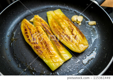 Delicious grilled eggplants with garlic on the fried pan 115361449