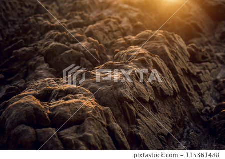 A large rocks surrounded by waves of the ocean 115361488