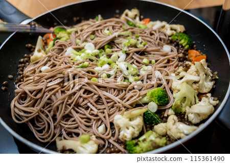 Chef at the kitchen preparing japanese buckwheat pasta with lentils Chef at the kitchen preparing japanese buckwheat pasta with lentils 115361490