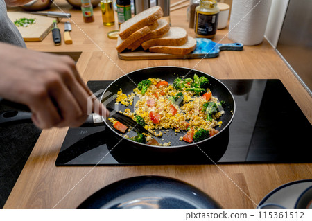 Chef at the kitchen preparing tofu scramble with vegetables 115361512