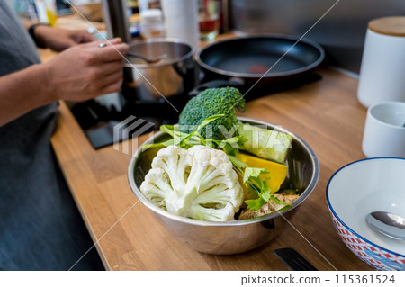 Chef at the kitchen preparing lentils soup with cauliflower and broccoli Chef at the kitchen preparing lentils soup with cauliflower and broccoli 115361524