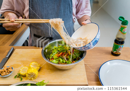 Chef at the kitchen preparing spicy glass noodle salad Chef at the kitchen preparing spicy glass noodle salad 115361544
