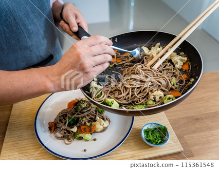 Chef at the kitchen preparing japanese buckwheat pasta with lentils 115361548