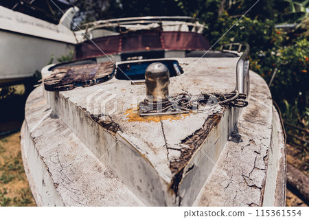 Old and rusty motor boats on a landfill surrounded by tropical forest 115361554