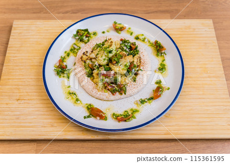 Tasty bean porridge with cauliflower and vegetables on white plate 115361595