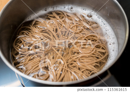 Chef at the kitchen preparing japanese buckwheat pasta with lentils 115361615