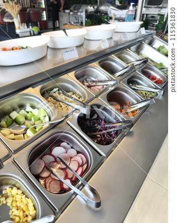 Buffet table stocked with an array of salads and veggies 115361830