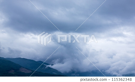 Rain clouds flowing over the mountaintop on a rainy day 115362348