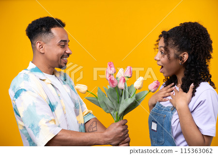 Two hipster friends smiling cheerfully while standing against a yellow background. High quality photo Two hipster friends smiling cheerfully while standing against a yellow background. High quality photo 115363062