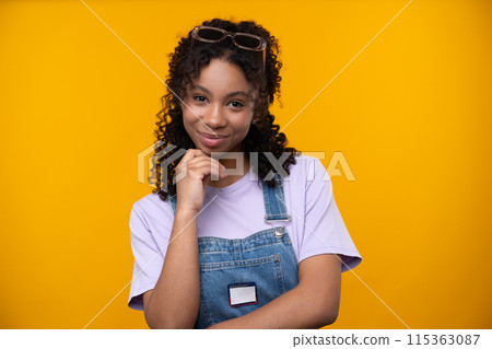 Happy emotions concept. Positive and beautiful young woman laughs poisitively looks aside with carefree face expression wears casual isolated over yellow studio background. Happy emotions concept. Positive and beautiful young woman laughs poisitively looks aside with carefree face expression wears casual isolated over yellow studio background. 115363087