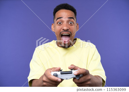 Emotional young black guy in casual raising fists up studio background, celebrating success, happy handsome african american millennial man sharing good emotions. Emotional young black guy in casual raising fists up studio background, celebrating success, happy handsome african american millennial man sharing good emotions. 115363099