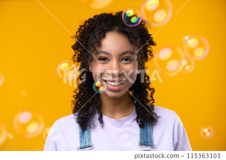 Happy emotions concept. Positive and beautiful young woman laughs poisitively looks aside with carefree face expression wears casual isolated over yellow studio background. 115363103