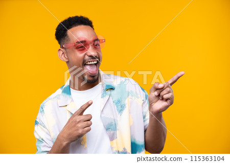 Emotional young black guy in casual raising fists up studio background, celebrating success, happy handsome african american millennial man sharing good emotions. 115363104