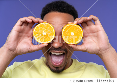 Emotional young black guy in casual raising fists up studio background, celebrating success, happy handsome african american millennial man sharing good emotions. 115363105