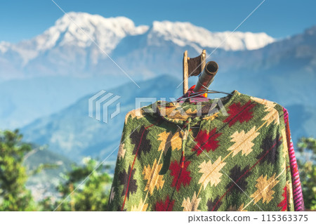 Ponchos hanging in front of mountain, Annapurna, Nepal 115363375
