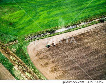 harvester plowing field in spring 115363457