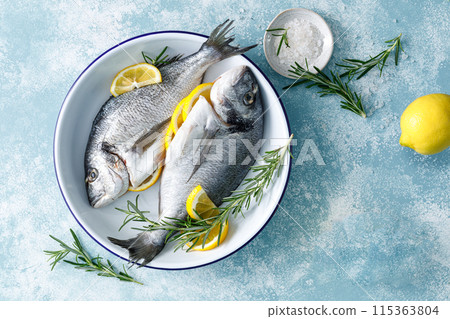 Fresh raw dorado fish cooking with lemon and rosemary. Sea bream, dorado. Seafood, healthy food. Top view Fresh raw dorado fish cooking with lemon and rosemary. Sea bream, dorado. Seafood, healthy food. Top view 115363804