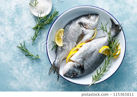 Fresh raw dorado fish cooking with lemon and rosemary. Sea bream, dorado. Seafood, healthy food. Top view 115363811