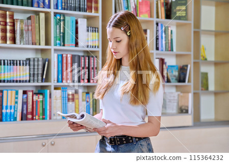 Portrait of serious teenage girl student reading book, inside high school building 115364232