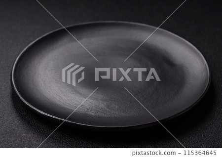 Empty ceramic round plate on dark textured concrete background 115364645