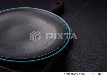 Empty ceramic round plate on dark textured concrete background Empty ceramic round plate on dark textured concrete background 115364648