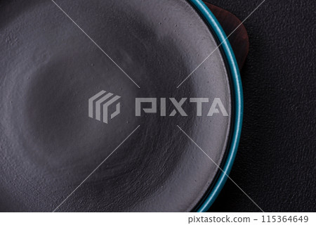 Empty ceramic round plate on dark textured concrete background Empty ceramic round plate on dark textured concrete background 115364649