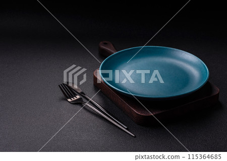 Empty ceramic round plate on dark textured concrete background 115364685
