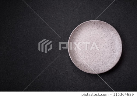 Empty ceramic round plate on dark textured concrete background 115364689