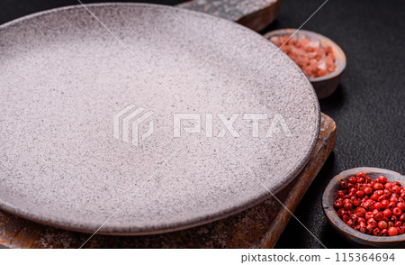 Empty ceramic round plate on dark textured concrete background 115364694