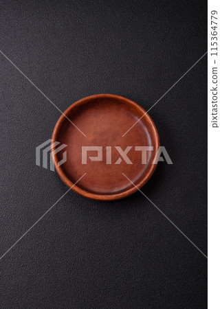 Empty ceramic round plate on dark textured concrete background Empty ceramic round plate on dark textured concrete background 115364779