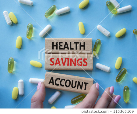 Health Saving Account symbol. Concept word Health Saving Account on wooden blocks. Doctor hand. Beautiful blue background with pills. Medicine and Health Saving Account concept. Copy space 115365109