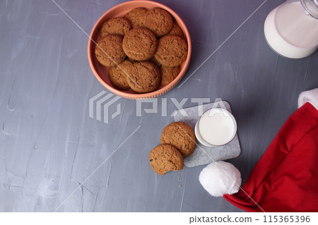 Treat for Santa Claus, cookies on a plate, glass of milk on a gray background, space for text, copyspace, top view, top view 115365396