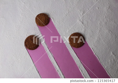 Three cookies on a white background with a trajectory of movement. Conceptual art photo Three cookies on a white background with a trajectory of movement. Conceptual art photo 115365417